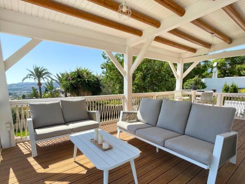 a patio with two couches and a table on a deck at Spanish charm guest apartment at villa with great location! in Las Lagunas Mijas