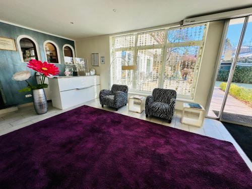 a room with two chairs and a purple rug at Boutique Hotel Oase in Bad Ischl