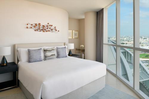 InterContinental Residence Suites Dubai Festival City, an IHG Hotel في دبي: غرفة نوم بسرير ابيض ونافذة كبيرة