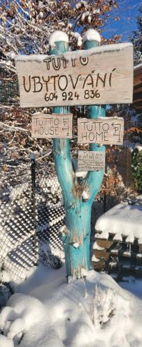 un letrero de la calle en la nieve con letreros. en TUTTO House&Home en Lubno