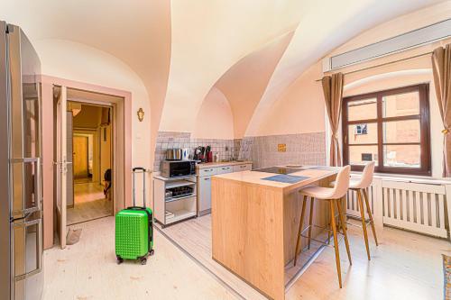 a kitchen with an island and a green suitcase at Komló Apartman - Stefan in Kőszeg