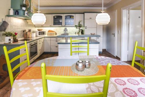 Immenhof في فلنسبورغ: مطبخ مع طاولة وكراسي صفراء في مطبخ