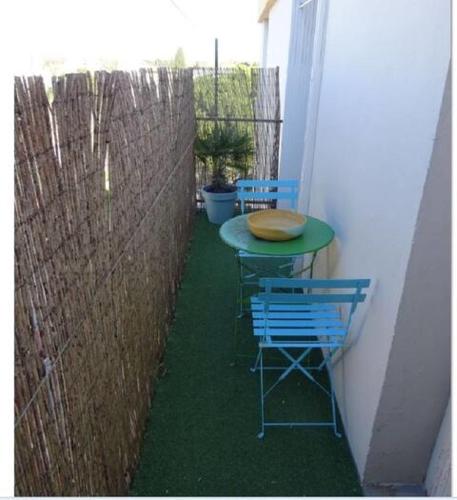 d'une petite terrasse avec une table et deux chaises. dans l'établissement Les Tourterelles d'Avignon, à Avignon