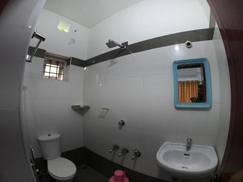 a bathroom with a toilet and a sink at Kripa Residency in Cochin