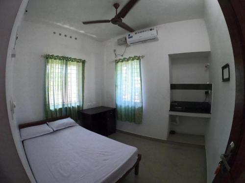1 dormitorio con 1 cama y ventilador de techo en Kripa Residency, en Kochi