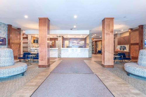 a lobby with two chairs and a bar at Sandman Hotel Edmonton West in Edmonton