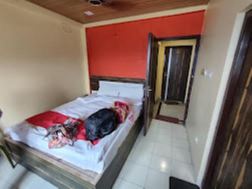 ein Bett in einem Zimmer mit einem Hund, der darauf liegt in der Unterkunft Hotel Kalash , Kalimpong in Kalimpong
