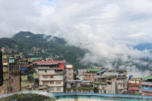 eine Gruppe von Gebäuden in einer Stadt mit einem Berg in der Unterkunft Hotel Kalash , Kalimpong in Kalimpong