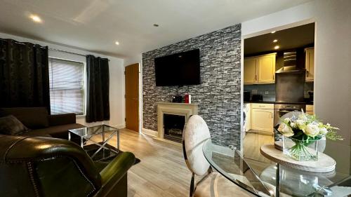 a living room with a fireplace and a table with flowers at One Bedroom Flat Town Centre Colchester in Colchester