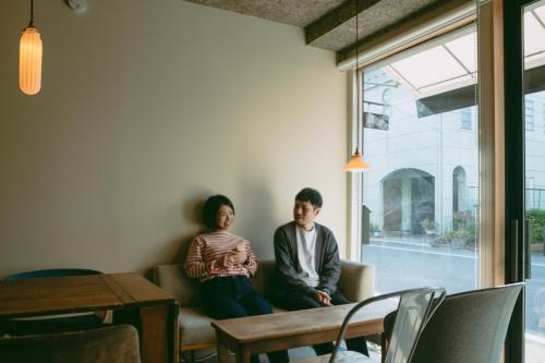 mężczyzna i kobieta siedzący na kanapie w obiekcie Sumida Nagaya w Tokio
