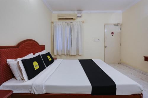 - une chambre avec un lit et des oreillers noirs et blancs dans l'établissement Super Collection O G Silver Polonest, à Bangalore