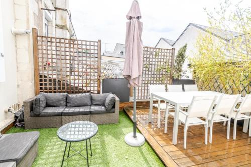 un patio avec un canapé, une table et des chaises dans l'établissement Dans les hauteurs d'Amboise, à Amboise