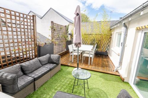 un patio avec un canapé et une table sur une terrasse dans l'établissement Dans les hauteurs d'Amboise, à Amboise