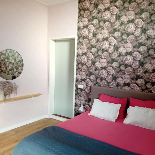 um quarto com uma cama com uma parede floral em Boukje har Bêd en Brochje em Bergum