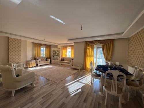a large living room with a table and chairs at Çamlarkent Villaları 