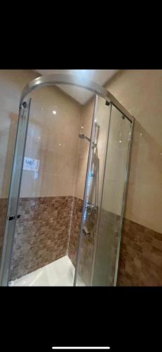 a shower with a glass door in a bathroom at Residence kettani Bouznika in Bouznika