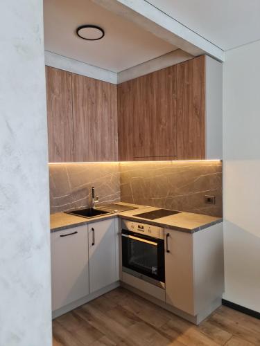 a kitchen with white cabinets and a sink at Studio apartamentas su balkonu in Vilnius