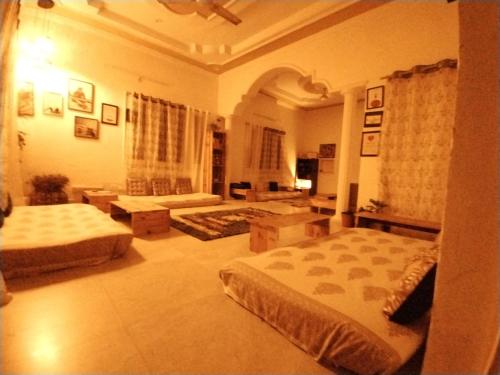 a bedroom with two beds and a living room at Bakri Chhap Stays The Senti Niketan in Dehradun