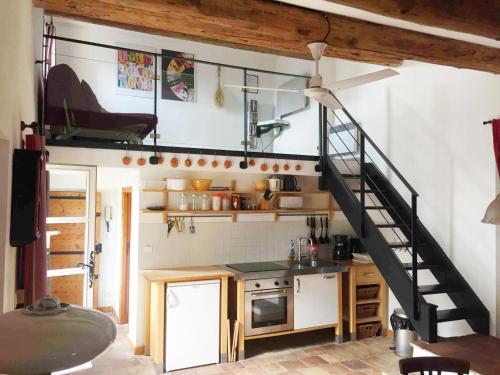 une cuisine avec un escalier menant à un loft dans l'établissement La Sapinière, à Uzès