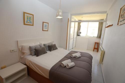 a bedroom with a bed with two towels on it at DIFFERENTFLATS Aquario in La Pineda