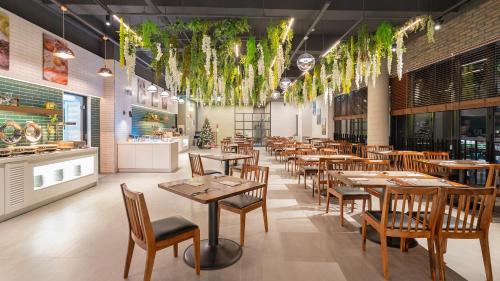 uma sala de jantar com mesas e cadeiras de madeira em Hotel Schweizer Dorf Cheonan em Cheonan