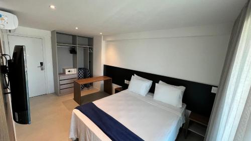 a hotel room with a bed and a television at Studios Premium RN in Maceió