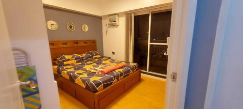 a bedroom with a bed with orange pillows on it at Cozy and Big Unit in Torre de Manila in Manila