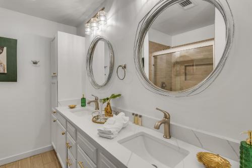 een witte badkamer met een wastafel en een spiegel bij The Beverly in Destin