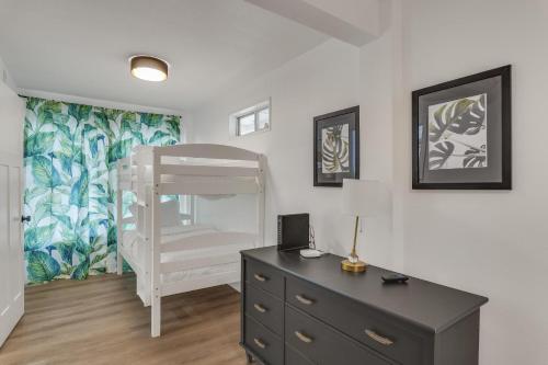 een slaapkamer met een bed en een dressoir met een bureau bij The Beverly in Destin