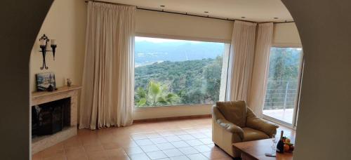 a living room with a large window and a chair at Villa Mas Nou in Castillo de Aro