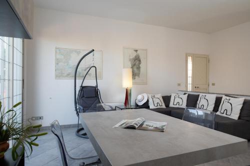 una sala de estar con una mesa y un sofá en Casa Marisa by Wonderful Italy, en Golfo Aranci