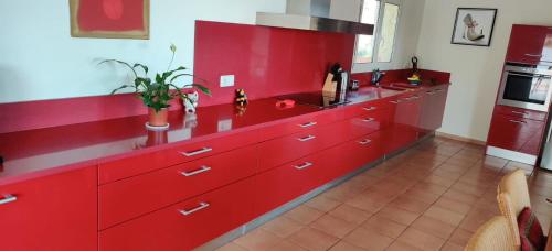 a kitchen with red cabinets and a red counter top at Villa Mas Nou in Castillo de Aro