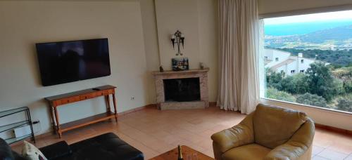 a living room with a television and a fireplace at Villa Mas Nou in Castillo de Aro
