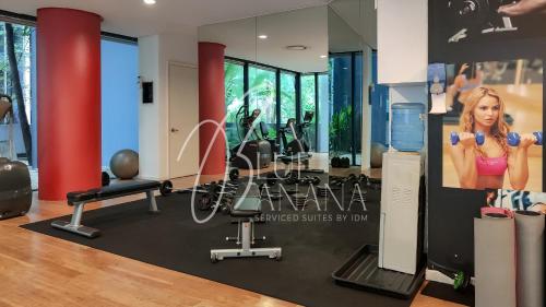 a gym with exercise equipment and a poster of a woman at St Mary Luxury Signature Suites, KLCC by BlueBanana in Kuala Lumpur