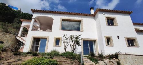 a white house on the side of a hill at Villa Mas Nou in Castillo de Aro
