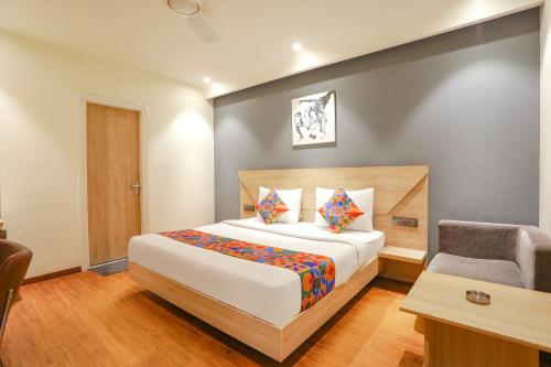 a bedroom with a bed and a desk and a chair at FabHotel JHS Studio in Gurgaon