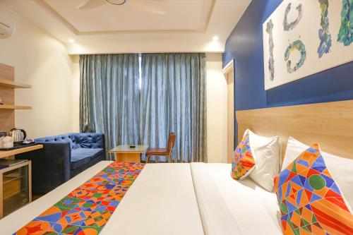 a hotel room with a bed and a chair at FabHotel JHS Studio in Gurgaon