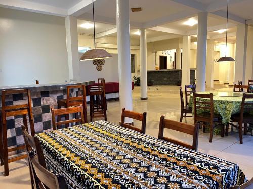 a dining room with a table and a table and chairs at Victoria Rock Resort in Entebbe