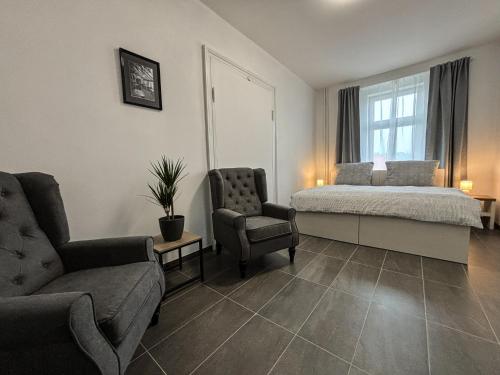a bedroom with a bed and a couch and a chair at Apartmány Plzeň Rolnické náměstí 8 in Plzeň