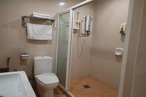 een badkamer met een douche, een toilet en een wastafel bij Hotel D'New 1 KK Sabah in Donggongon