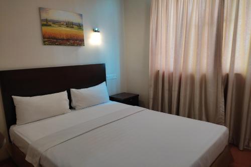 a bedroom with a large white bed and a window at Hotel D'New 1 KK Sabah in Donggongon
