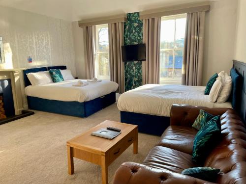 um quarto de hotel com duas camas e um sofá em Turks Head Rothbury em Rothbury