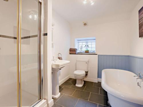 a bathroom with a toilet and a tub and a sink at 2 Bed in Barnstaple 88125 in Swimbridge