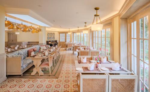 a restaurant with tables and chairs and windows at Gateway Coonoor - IHCL SeleQtions in Coonoor