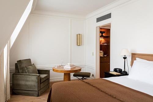Hôtel Balzac Paris في باريس: غرفة نوم بسرير وكرسي وطاولة