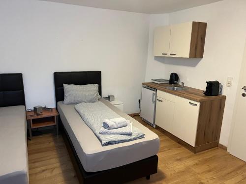 ein kleines Zimmer mit einem Bett und einer kleinen Küche in der Unterkunft Roccos Raum in Kapfenberg
