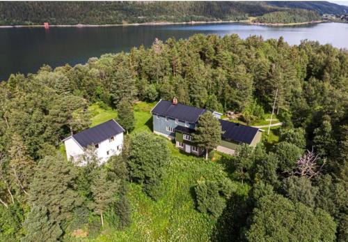 una vista aérea de una casa en medio de un lago en Unique totally private island in a Norwegian fjord with space for 40 people, a dinner room and a chapel, en Simle