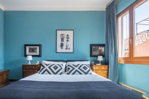 1 dormitorio azul con 1 cama y 2 ventanas en Saint Mark's view, en Venecia