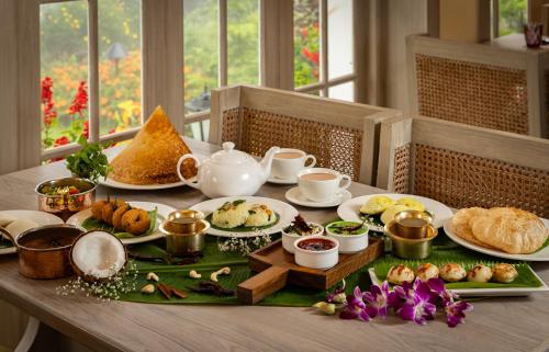 a table with plates of food on top at Gateway Coonoor in Coonoor