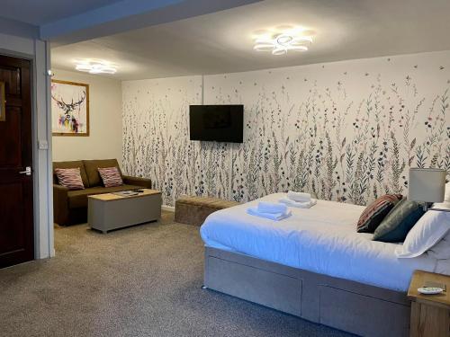 a bedroom with a bed and a tv and a couch at Turks Head Rothbury in Rothbury